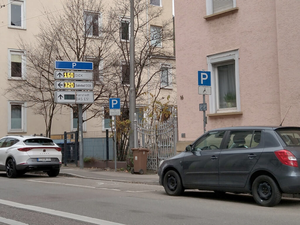 Behindertenparkplatz entlang der Straße, vor einem Haus mit der Nummer 16.