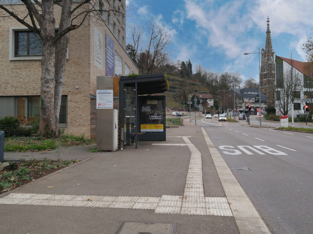 Bushaltestelle am Gehweg mit Blindenleitsystem und erhöhtem Bordstein.